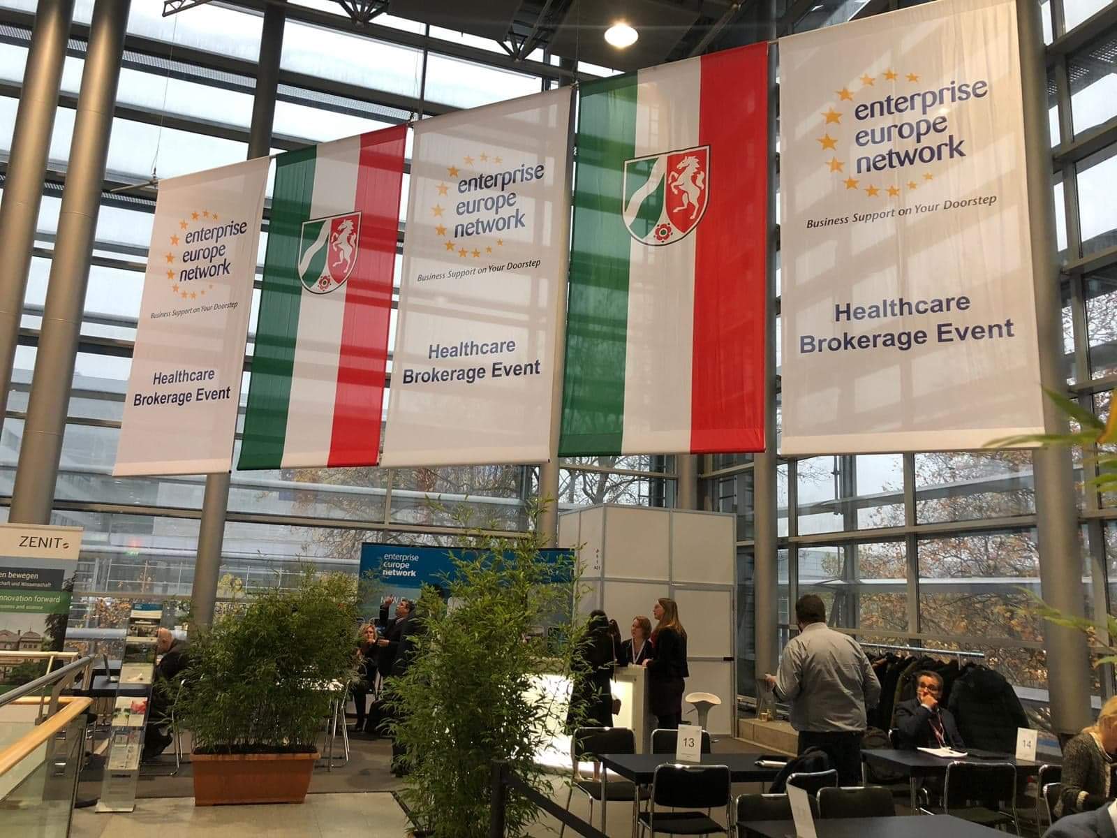 Widok na wnętrze przeszklonego pomieszczenia. Z sufitu zwisają flagi z napisem Enterprise Europe...