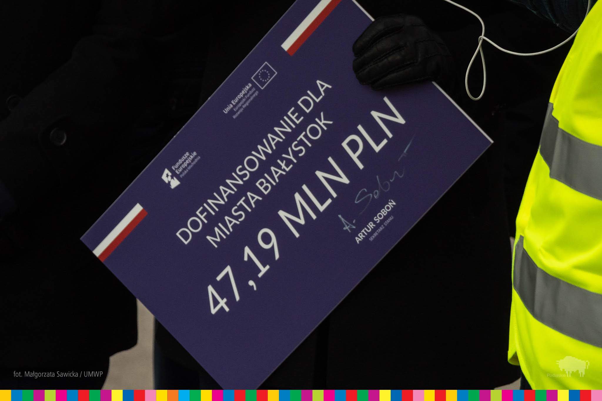 Na czarnym tle widać fioletowy prostokąt, na którym jest napisane "Dofinansowanie dla miasta Białystok 47,19 mln pln"