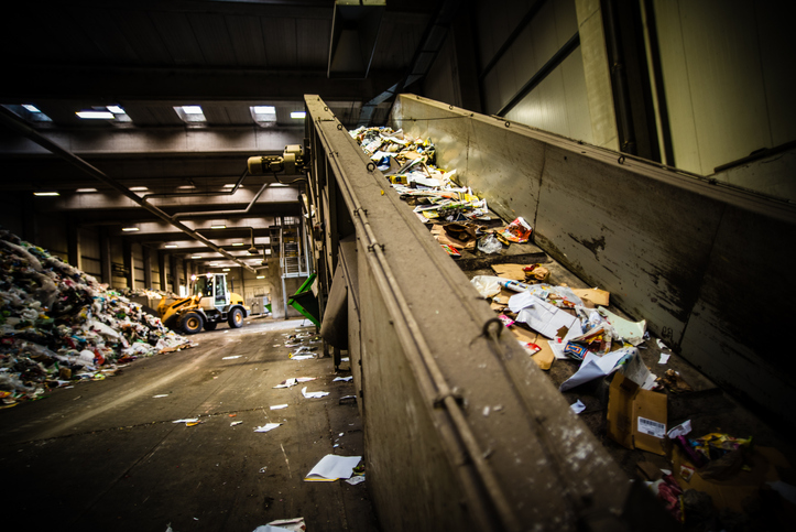Widok taśmy sortującej odpady w zakładzie przetwarzającym odpady. Na pierwszym planie widoczne...