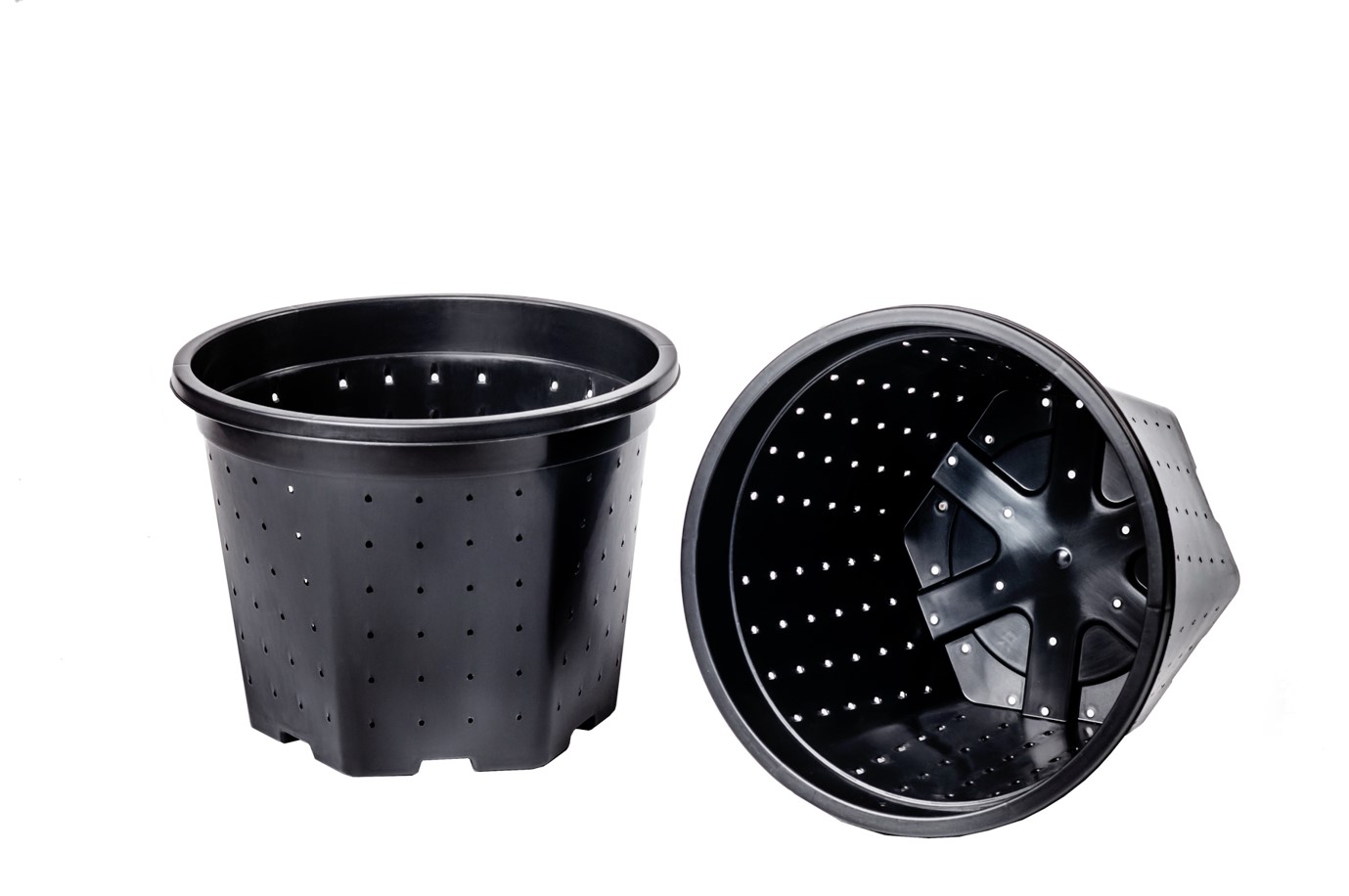 Na białym tle widać dwie czarne doniczki. Jedną w pionie, drugą poziomie, tak, że widać jej wnętrze. Boki oraz dno doniczek pokrywają malutkie dziurki