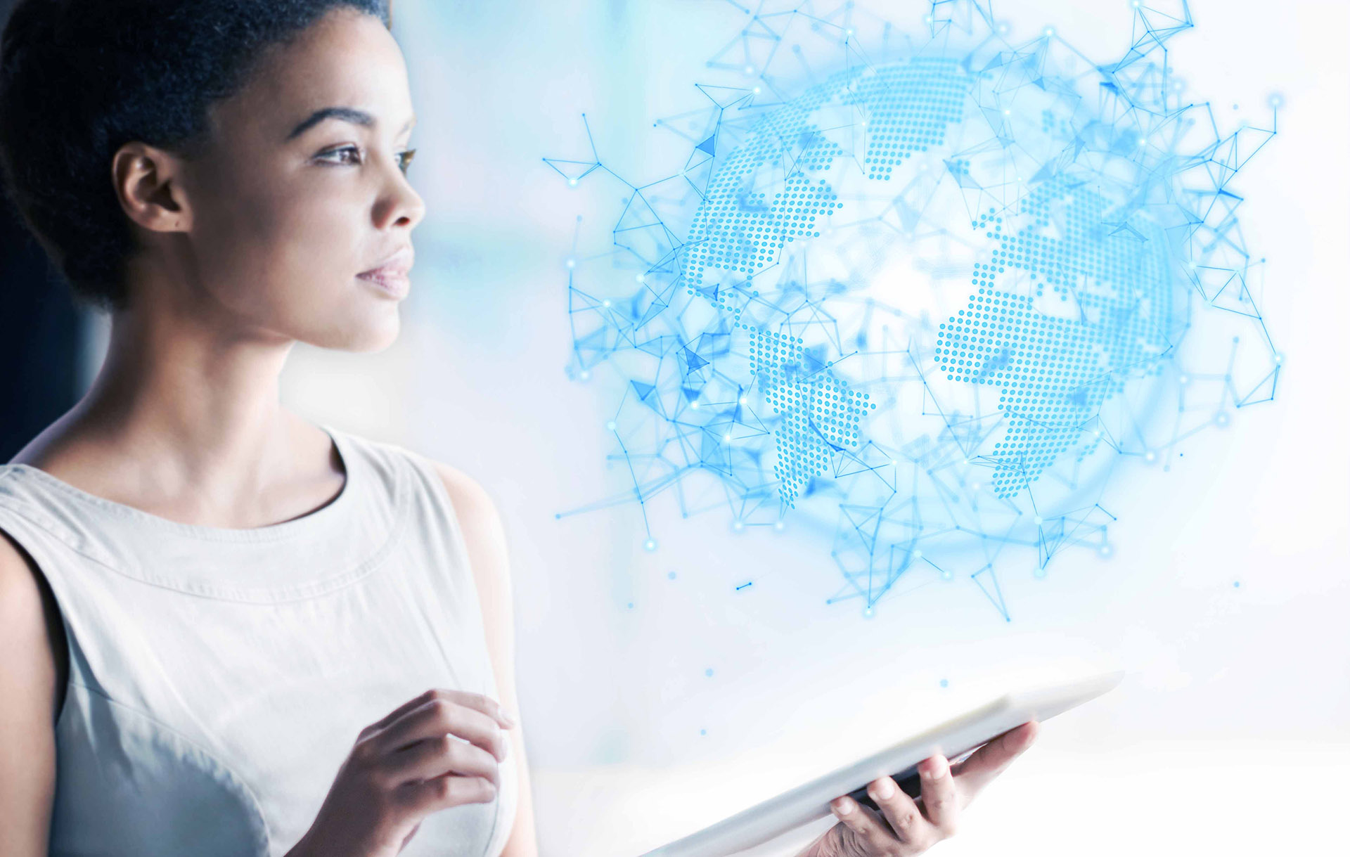 Ciemnoskóra kobieta w średnim trzyma w ręce tablet i patrzy na abstrakcyjną sferę przypominającą kulę ziemską