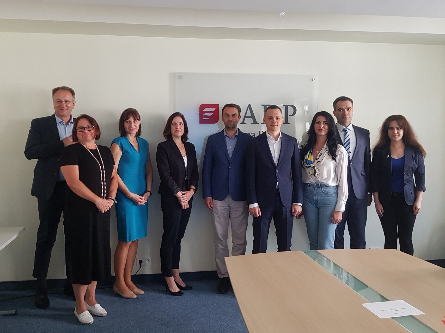 ludzie w różnym wieku zgromadzeni w niewielkiej sali pozują do wspólnego zdjęcia