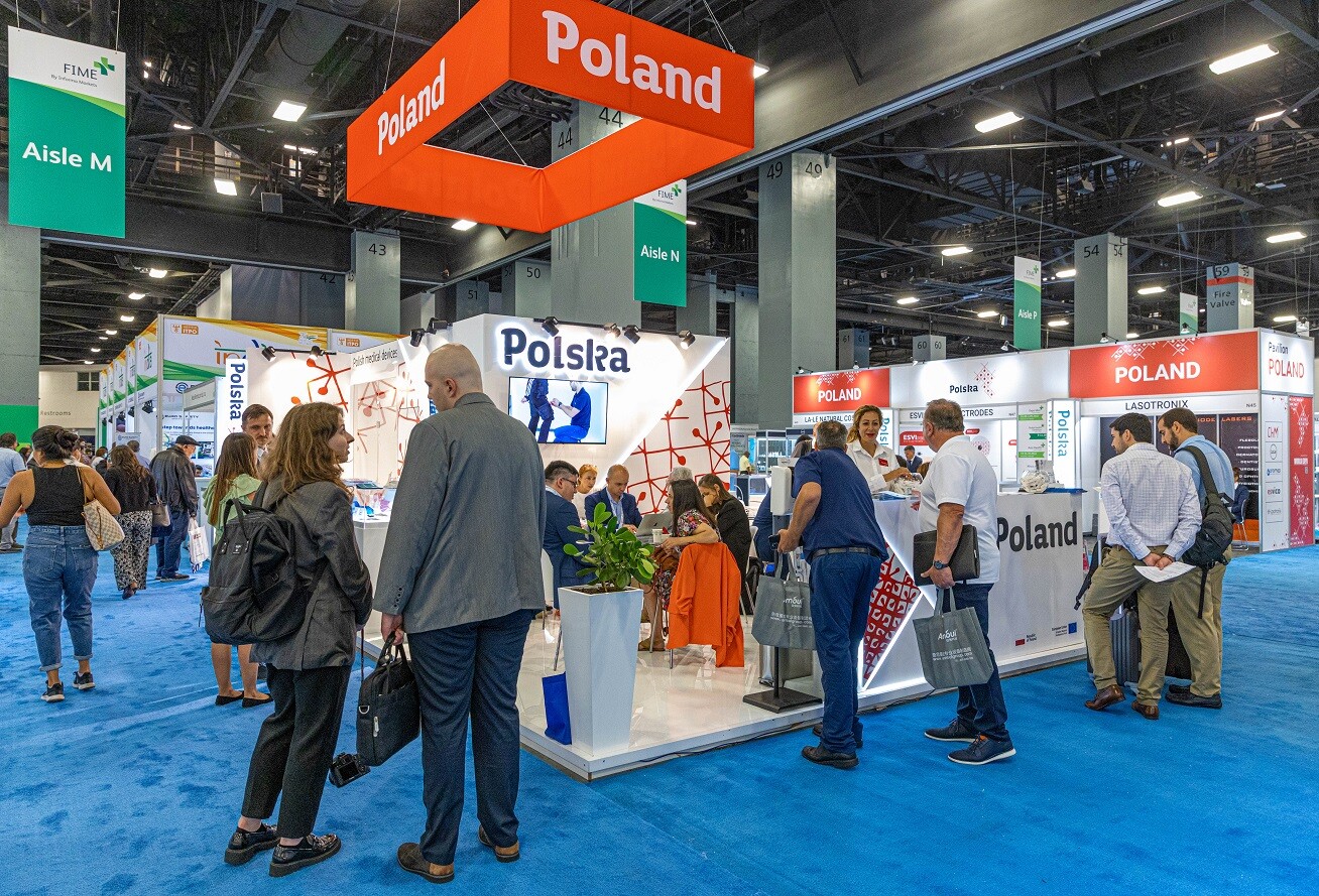 ludzie w hali wystawienniczej siedzą przy stolikach