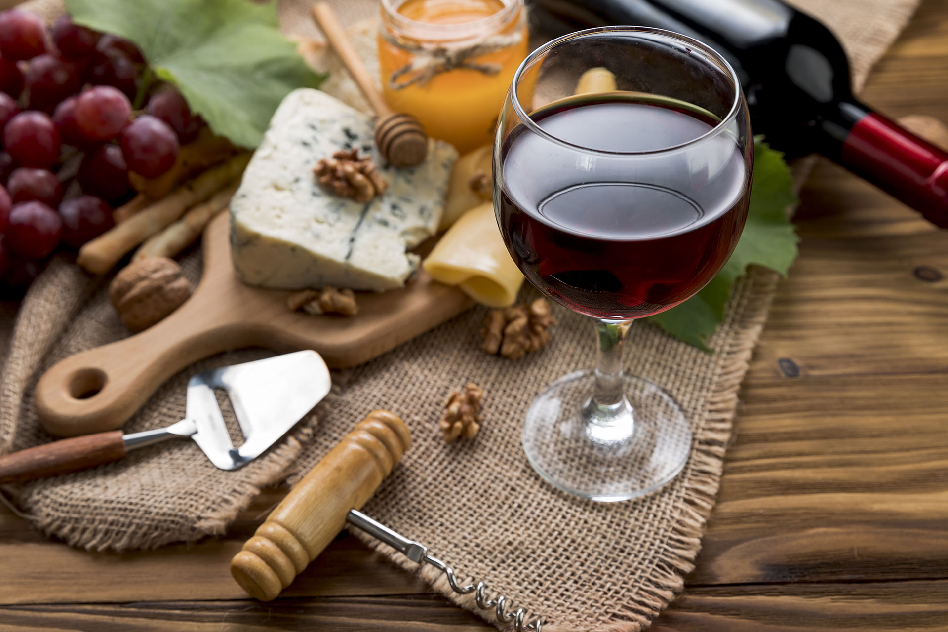 widok na kieliszek wina, orzechy, ser i winogrona