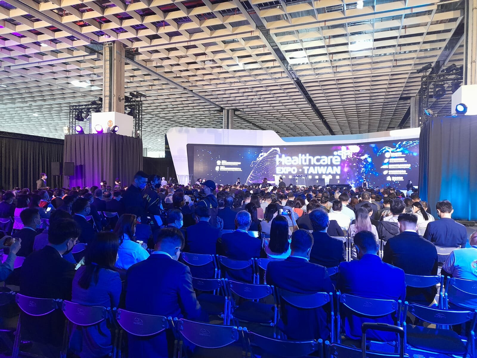 Ludzie siedzą na sali konferencyjnej zwróceni w stronę podium