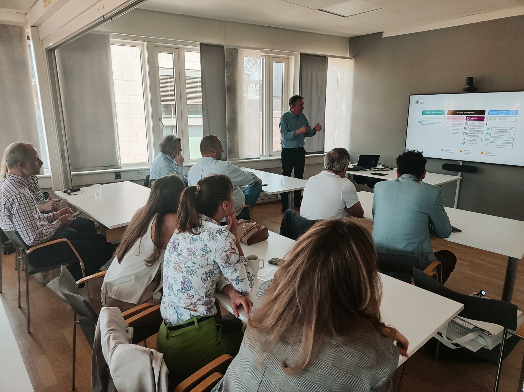 Ludzie siedzą na sali i patrzą się w telebim