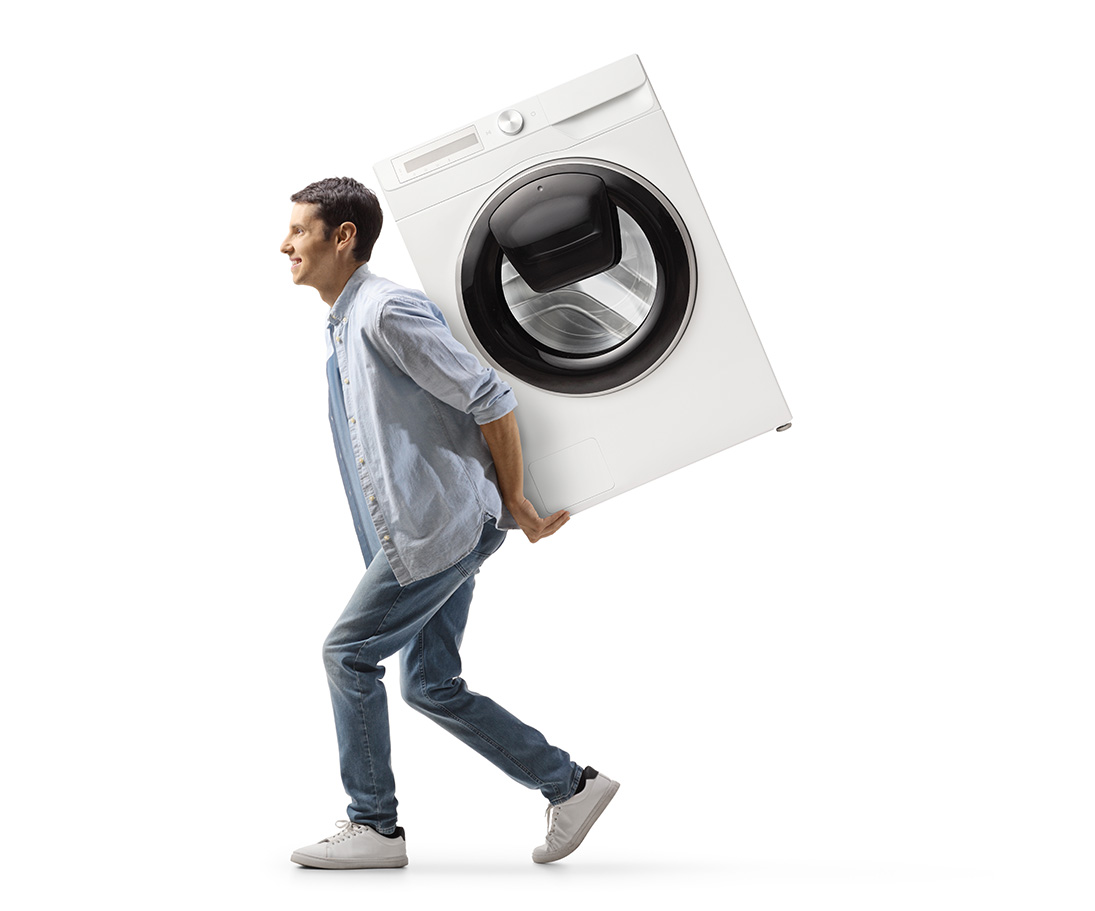 Człowiek niesie pralke na plecach