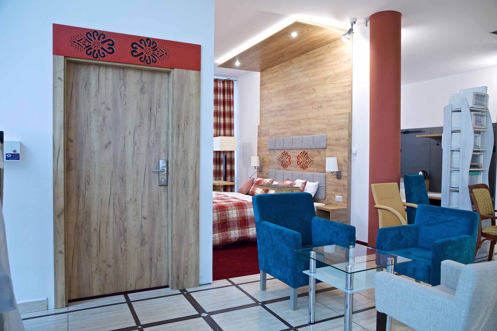 Widok łóżka z białym zagłówkiem i granatową narzutą 