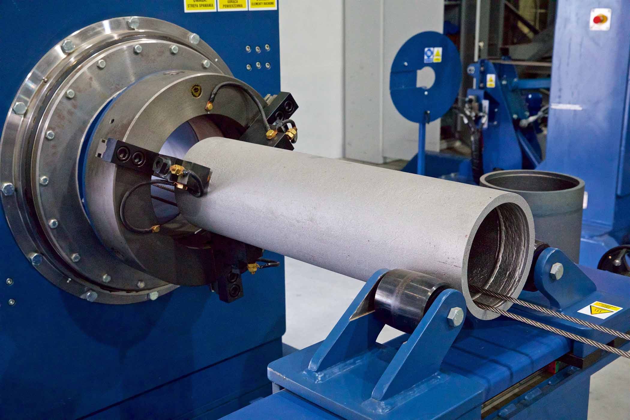 Zdjęcie dużej szarej rury w maszynie na hali produkcyjnej